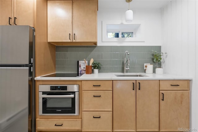 kitchen with sink, backsplash, hanging light fixtures, stainless steel appliances, and light brown cabinets