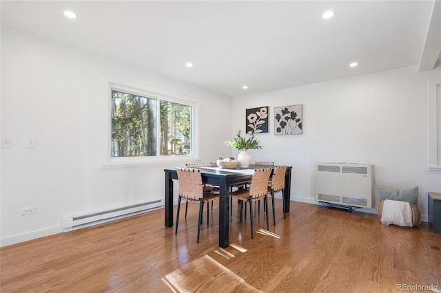 dining room with light wood-type flooring, heating unit, and a baseboard heating unit