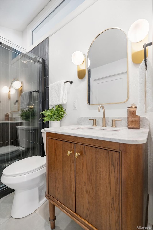 bathroom featuring a shower with door, vanity, tile patterned flooring, and toilet