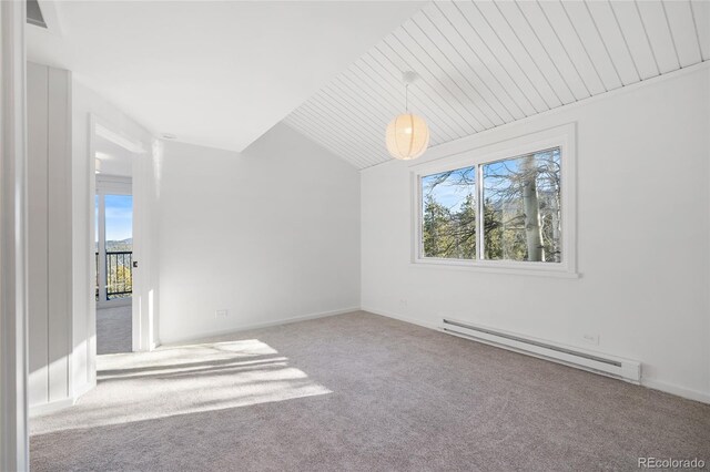 empty room featuring lofted ceiling, a baseboard heating unit, and carpet floors