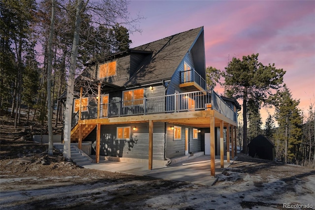 back house at dusk featuring a patio