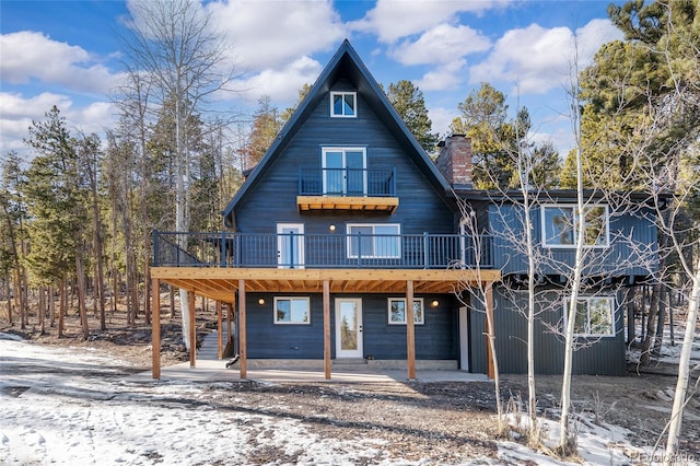 view of front of house featuring a wooden deck and a patio