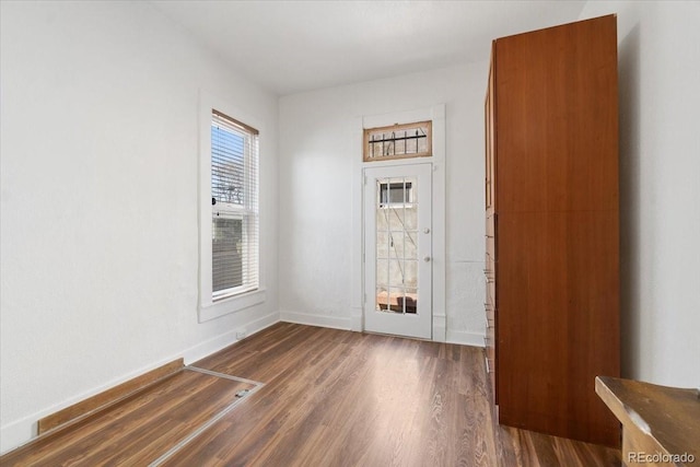 foyer featuring dark wood-style flooring and baseboards