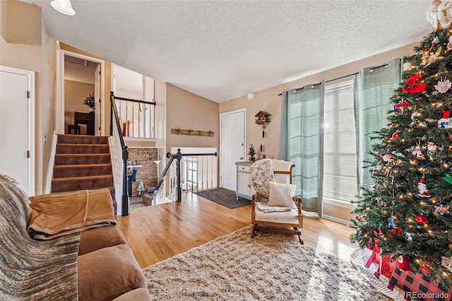 living area featuring a healthy amount of sunlight, wood-type flooring, and a textured ceiling