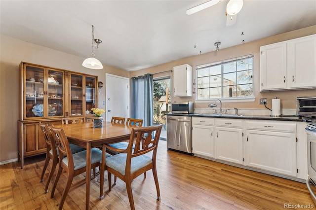 dining space with ceiling fan, sink, and light hardwood / wood-style flooring