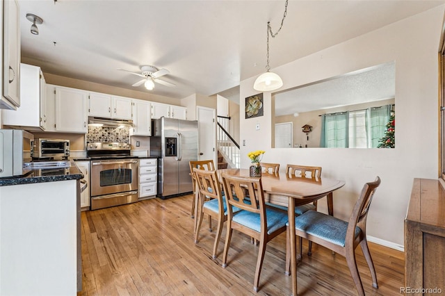 kitchen featuring ceiling fan, backsplash, pendant lighting, white cabinets, and appliances with stainless steel finishes