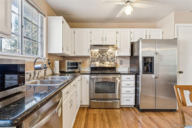 kitchen featuring white cabinetry, sink, ceiling fan, stainless steel appliances, and light hardwood / wood-style flooring