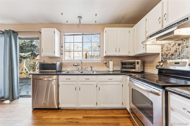 kitchen with sink, white cabinets, stainless steel appliances, and light wood-type flooring