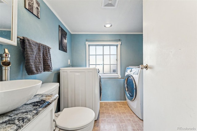 bathroom featuring washer and clothes dryer, vanity, toilet, and ornamental molding