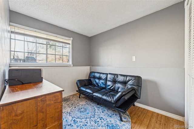 living area with hardwood / wood-style floors and a textured ceiling