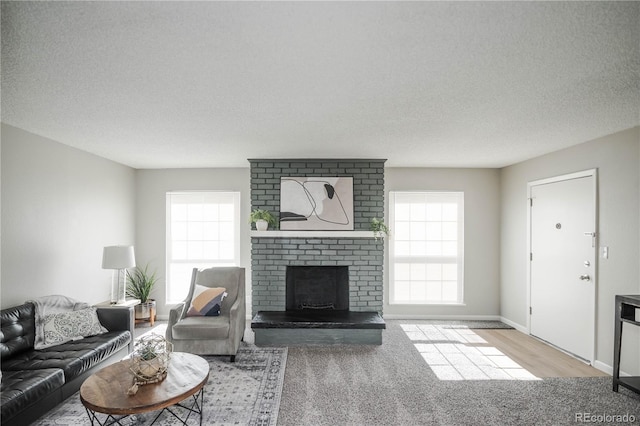 3855 S Monaco St Unit 208, Denver, CO 80237 - living area featuring healthy amount of natural light, a fireplace, a textured ceiling, and carpet flooring