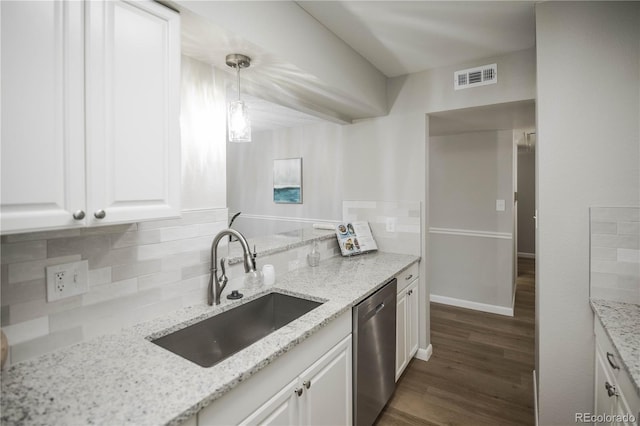 3855 S Monaco St Unit 208, Denver, CO 80237 - kitchen with stainless steel dishwasher, white cabinets, dark wood-style floors, and tasteful backsplash