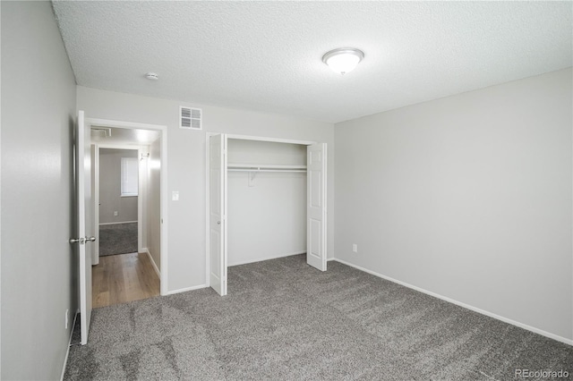 3855 S Monaco St Unit 208, Denver, CO 80237 - unfurnished bedroom featuring carpet floors, a textured ceiling, and a closet