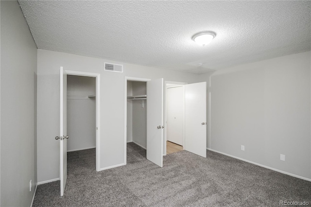 3855 S Monaco St Unit 208, Denver, CO 80237 - unfurnished bedroom with carpet floors, a textured ceiling, and two closets