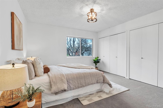 4248 Corriente Pl, Boulder, CO 80301 - carpeted bedroom featuring two closets, a textured ceiling, and a chandelier