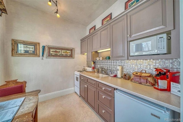 kitchen with white appliances, sink, and backsplash