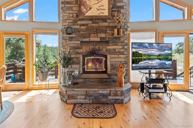 living room featuring wood-type flooring, a healthy amount of sunlight, and a towering ceiling