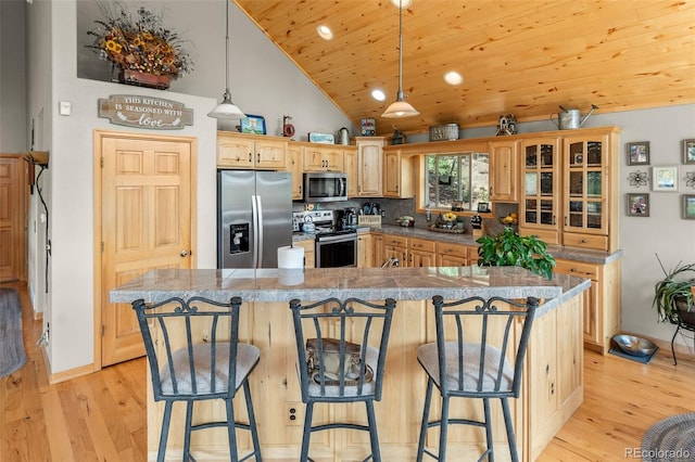 kitchen with wood ceiling, stainless steel appliances, a kitchen breakfast bar, and light hardwood / wood-style flooring