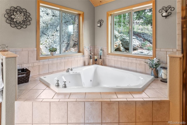 bathroom with lofted ceiling and tiled bath