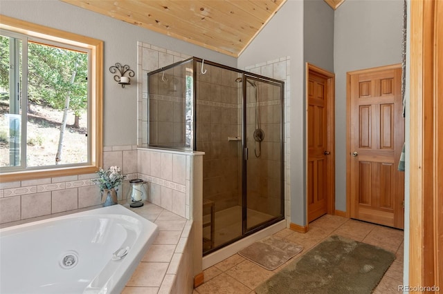 bathroom with tile patterned flooring, vaulted ceiling, shower with separate bathtub, and a healthy amount of sunlight