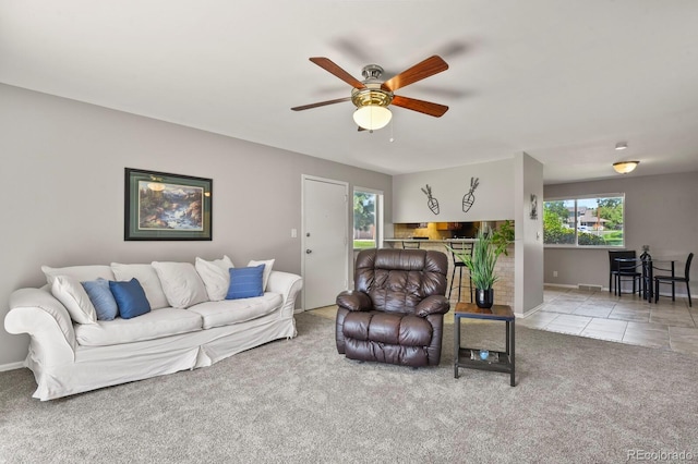 tiled living room featuring carpet flooring, a ceiling fan, and baseboards