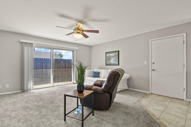 living area featuring light carpet, ceiling fan, and baseboards