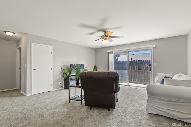 carpeted living room featuring baseboards and a ceiling fan