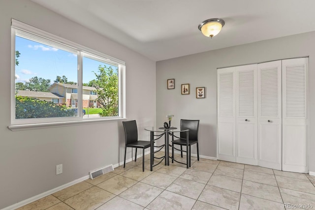 dining room featuring light tile patterned floors, visible vents, and baseboards