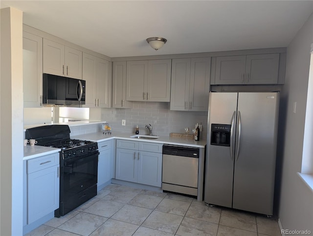 kitchen featuring stainless steel appliances, tasteful backsplash, a sink, and light countertops