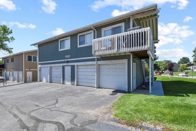 townhome / multi-family property featuring a balcony, a garage, and a front yard