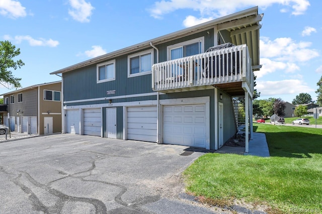 2246 N Coronado Pkwy Unit A, Denver, CO 80229 - view of front of house featuring a balcony, an attached garage, a front lawn, and asphalt driveway