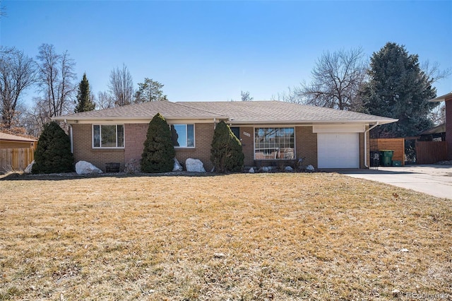 ranch-style home with brick siding, concrete driveway, an attached garage, a front yard, and fence