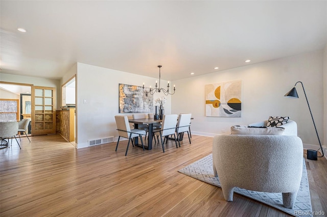 dining room with recessed lighting, visible vents, light wood-style flooring, and an inviting chandelier