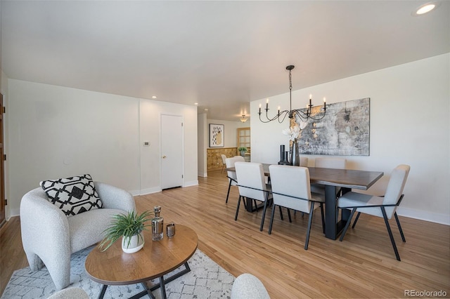 dining space featuring light wood-style floors, baseboards, an inviting chandelier, and recessed lighting