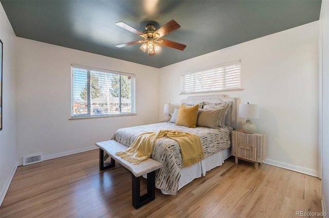 bedroom featuring baseboards, visible vents, and light wood finished floors