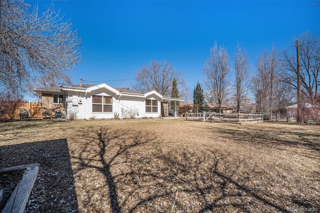 back of property featuring fence and a lawn