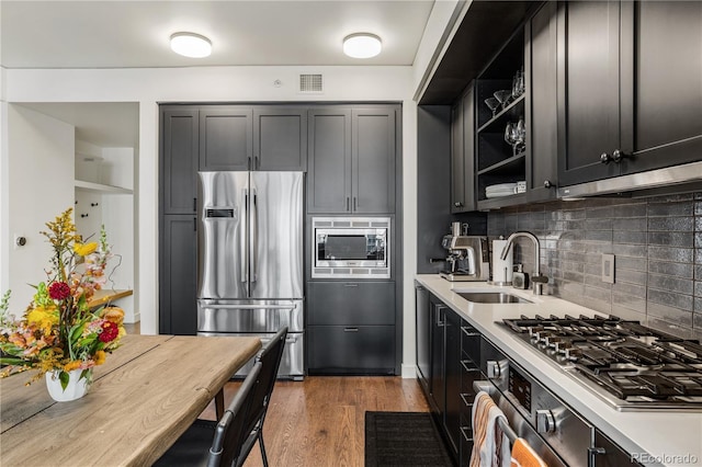 1750 Wewatta St Unit 525, Denver, CO 80202 - kitchen with appliances with stainless steel finishes, light countertops, decorative backsplash, wood finished floors, and open shelves