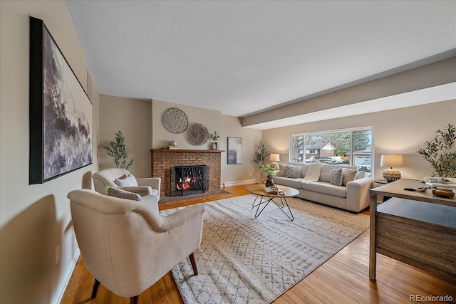 living room featuring a fireplace, wood finished floors, baseboards, and a baseboard heating unit