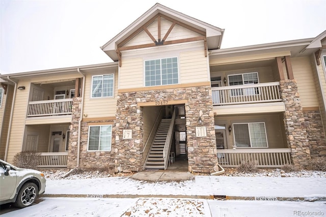 view of front of home featuring stone siding and stairway