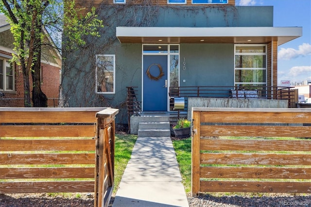 190 W Archer Pl, Denver, CO 80223 - view of front of home featuring a porch, stucco siding, and fence