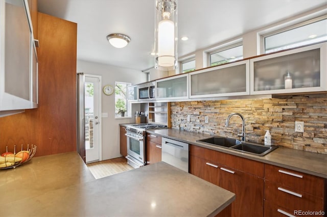 190 W Archer Pl, Denver, CO 80223 - kitchen with brown cabinets, a sink, stainless steel appliances, backsplash, and modern cabinets