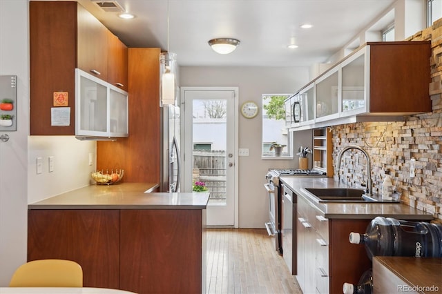 190 W Archer Pl, Denver, CO 80223 - kitchen with a sink, stainless steel appliances, light wood-type flooring, visible vents, and glass insert cabinets
