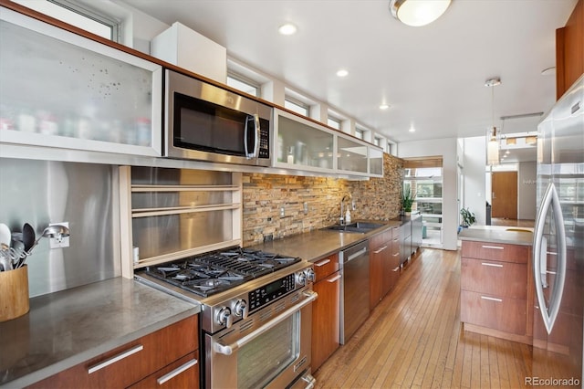 190 W Archer Pl, Denver, CO 80223 - kitchen with backsplash, stainless steel countertops, modern cabinets, a sink, and stainless steel appliances