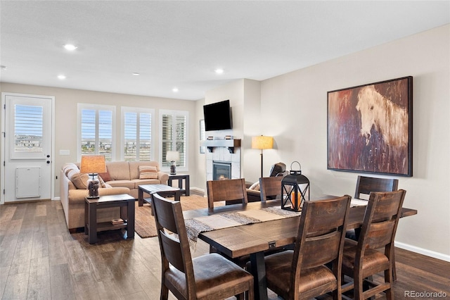 4475 Hidden Gulch Rd, Castle Rock, CO 80104 - dining room featuring a lit fireplace, hardwood / wood-style floors, baseboards, and recessed lighting