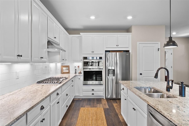 4475 Hidden Gulch Rd, Castle Rock, CO 80104 - kitchen with appliances with stainless steel finishes, a sink, under cabinet range hood, white cabinetry, and recessed lighting