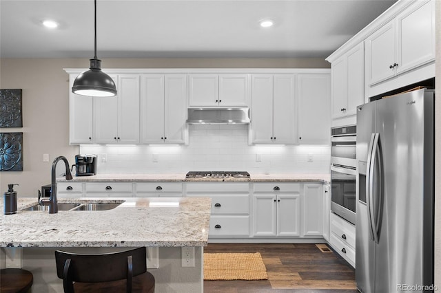 4475 Hidden Gulch Rd, Castle Rock, CO 80104 - kitchen with appliances with stainless steel finishes, under cabinet range hood, a sink, white cabinets, and dark wood-style flooring