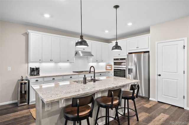 4475 Hidden Gulch Rd, Castle Rock, CO 80104 - kitchen with appliances with stainless steel finishes, a sink, beverage cooler, dark wood-type flooring, and decorative backsplash