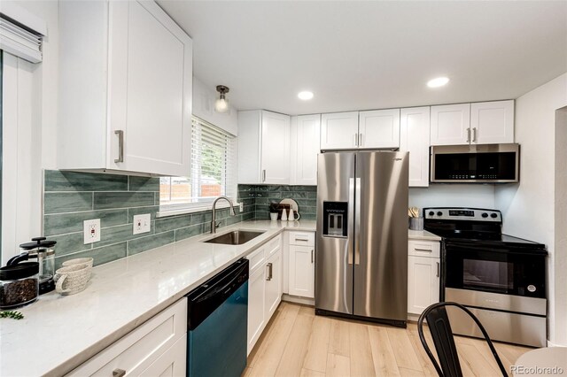 5780 W 5th Ave, Lakewood, CO 80226 - kitchen with stainless steel appliances, white cabinets, light wood-style flooring, and recessed lighting