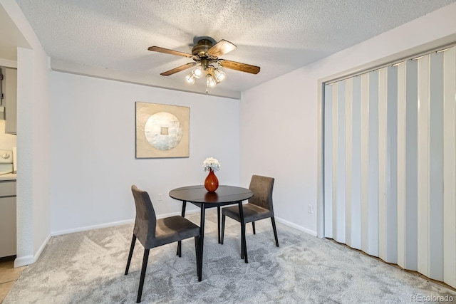 carpeted dining room featuring ceiling fan and a textured ceiling