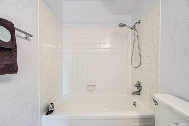 bathroom with tiled shower / bath and toilet